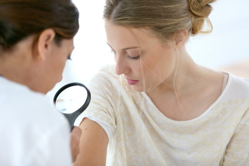 Dermatologist examining patient’s skin
