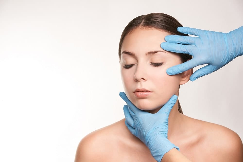 Dermatologist with Blue Rubber Gloves On Checking Woman’s Face